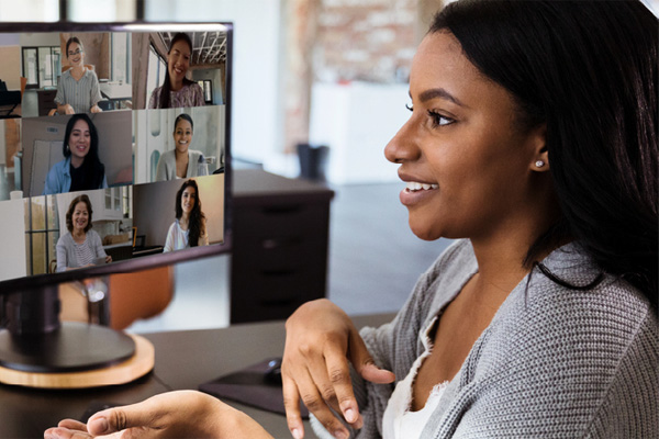 A woman smiling at a video meeting on her computer screen